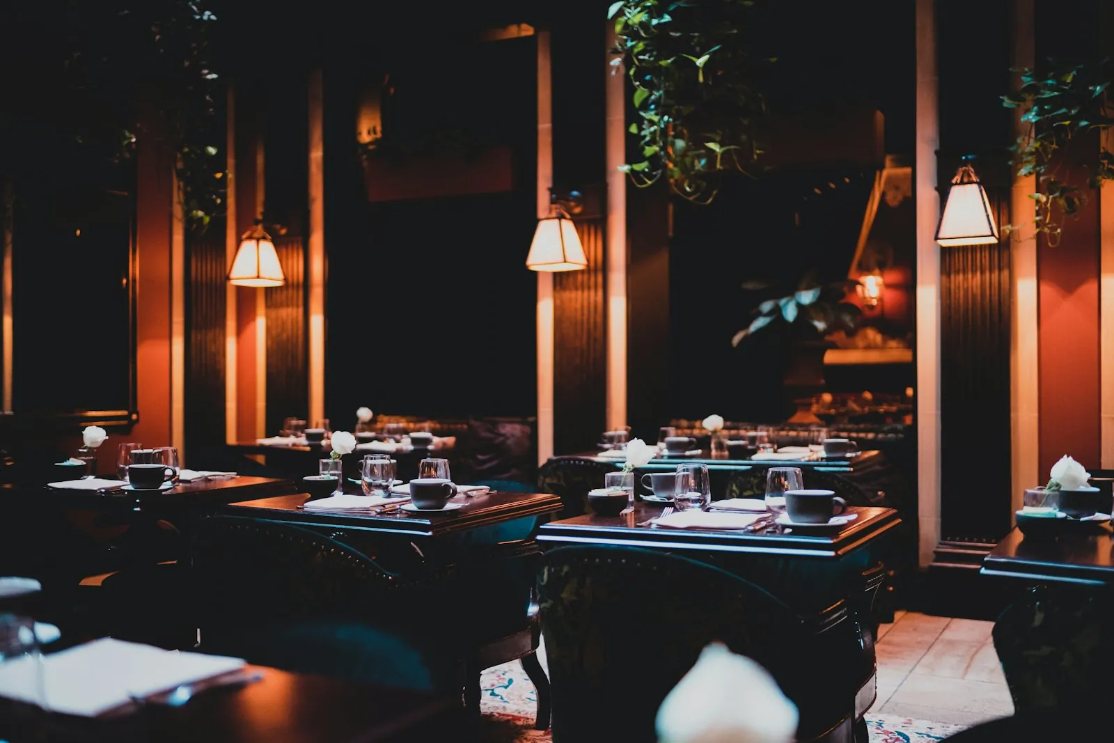 Pendant lamps hanging low over a dark dining room